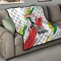 White quilt draped on sofa with diamond stitching, Martin Luther King portrait and colored stripes
