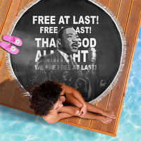 Circular black beach blanket with white tassel fringe, MLK portrait and “Free at last”