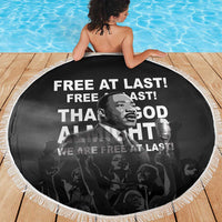 Round black beach blanket with white tassel fringe, MLK portrait graphic and slogan