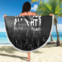 Black beach blanket with white fringe, MLK portrait and “Free at last” text, held up