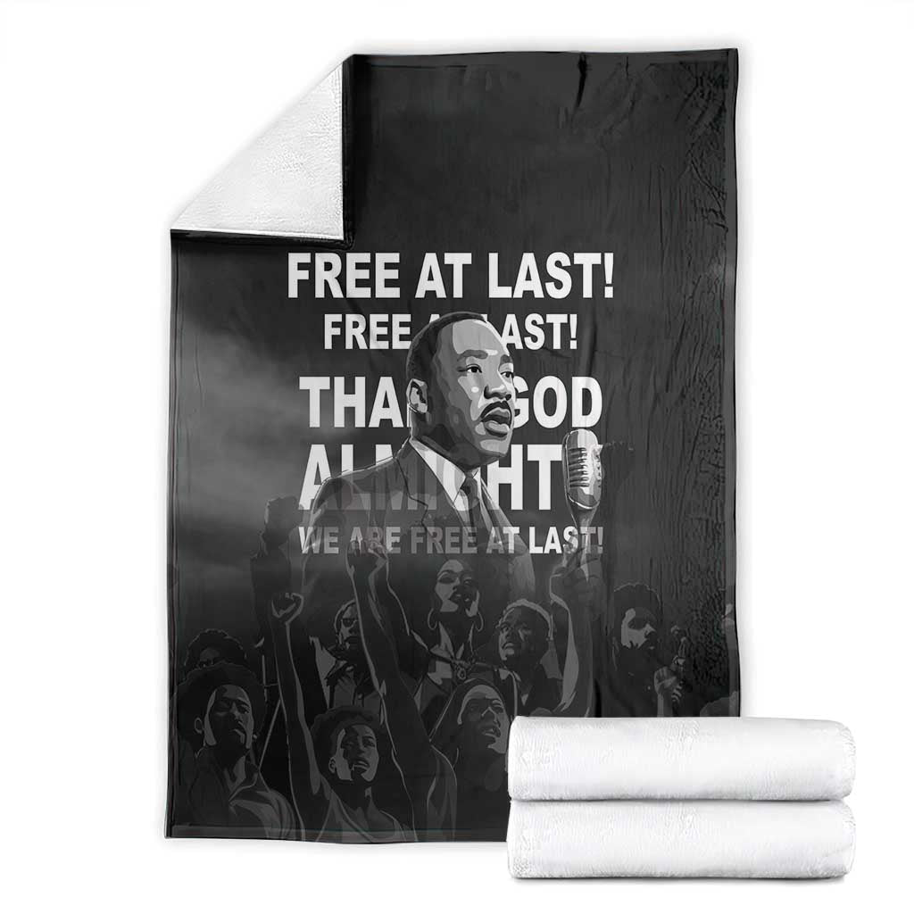 Black MLK portrait blanket with bold white text, folded bundle with two stacks