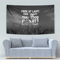 Black wall tapestry with Martin Luther King Jr portrait and quote text above a gray sofa