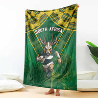 Green blanket with yellow patterned border, running springbok and "SOUTH AFRICA" text