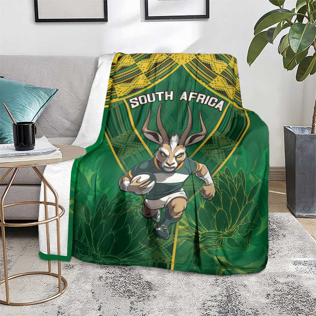 Green blanket with yellow patterned top and running springbok, "SOUTH AFRICA" text