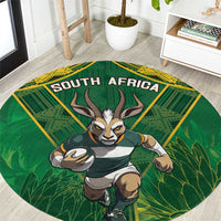 Round green rug with yellow border, South Africa text and antelope mascot graphic