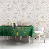 Green tablecloth with yellow border and leafy rugby pattern across dining table