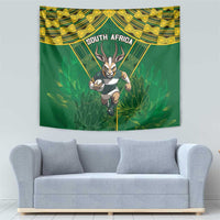 South Africa rugby tapestry on light wall, green and yellow tribal design with antelope figure