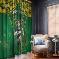Green window curtains with gold African design and antelope mascot, full-length view