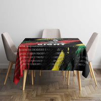 Black tablecloth on dining table with red, green, and yellow diagonal brush-style graphics