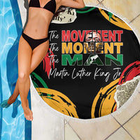 Black round beach blanket with fringe, “The Movement Moment Man” graphic by pool