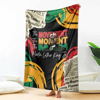 Black MLK legacy blanket with colorful fists and 'The Movement Man' text, held upright
