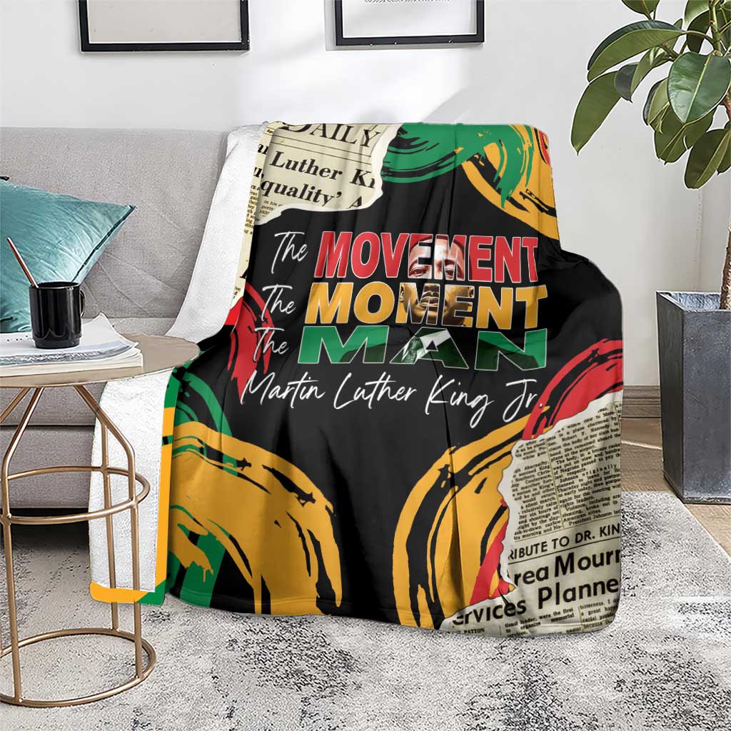 Black MLK legacy blanket with colorful fist artwork and 'The Movement Man' text, on sofa