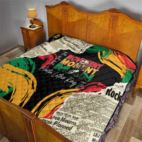 Black quilt with multicolor graphic design and quilted stitching, on bed set