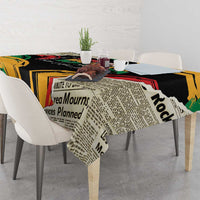Black tablecloth with newspaper-style text blocks and red/green/yellow accents on table.