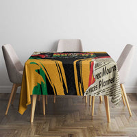 Black tablecloth with bold yellow stripe print and red/green accents on dining table.