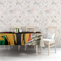 Rectangular black tablecloth with colorful typography print on dining table and chairs.