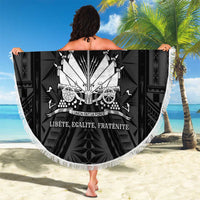 Round black beach blanket with white fringe and central crest banner design