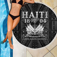 Close view of round fringed beach blanket with black background and “HAITI 1804” text