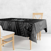 Black tablecloth with abstract geometric print, hanging over the table edge in front view.
