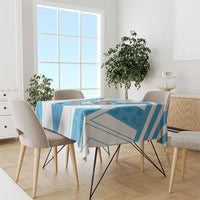 Blue and white geometric tablecloth on dining table with chairs and plants