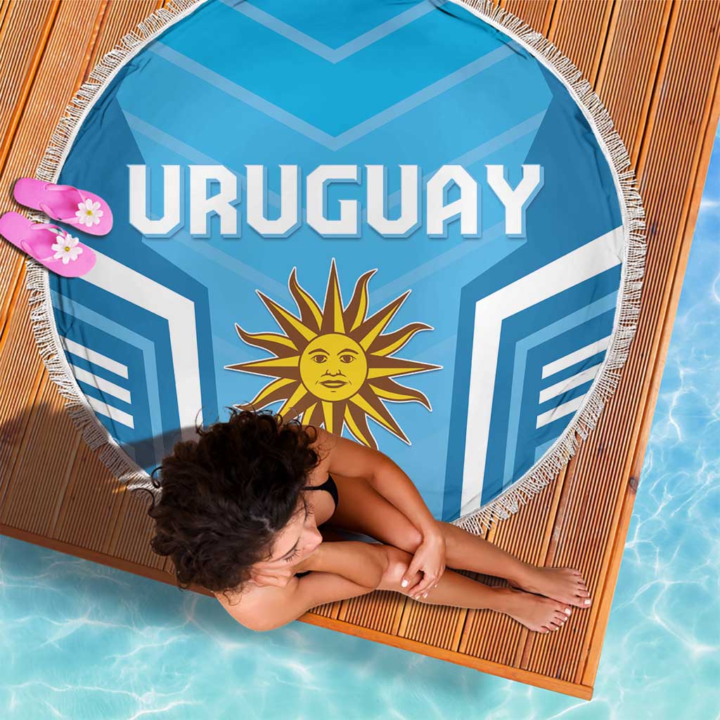 Round blue Uruguay beach blanket with white fringe, sun emblem, draped over body