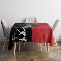 Red and black tablecloth with central Antigua and Barbuda crest on dining table