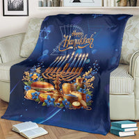 Blue Hanukkah blanket with menorah and 'Happy Hanukkah' text, draped over armchair.