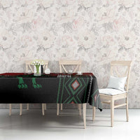 Red, black, and green rectangular tablecloth with geometric pattern bands on dining table