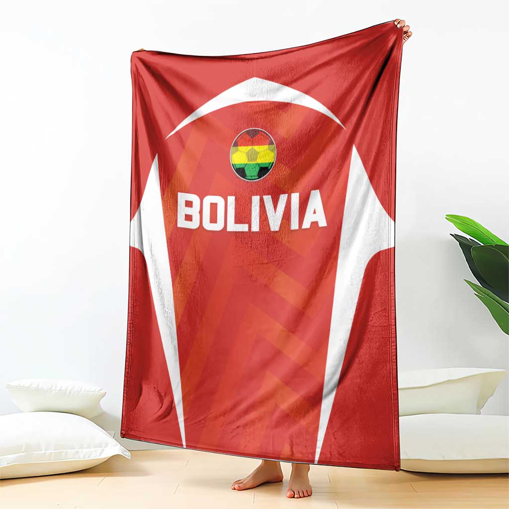 Red Bolivia football blanket with crest and bold BOLIVIA lettering, draped on bed