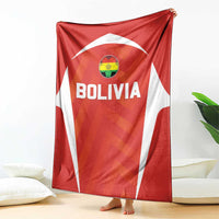 Red Bolivia football blanket with crest and bold BOLIVIA lettering, draped on bed