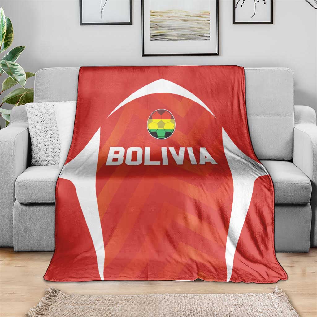 Red Bolivia football blanket with white cape pattern, crest above BOLIVIA text on sofa