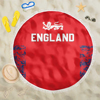 Red round England beach blanket with white fringe and lion crest above “ENGLAND” text.