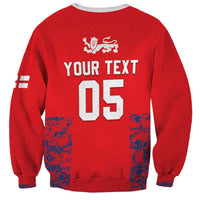 Red cricket sweatshirt back with YOUR TEXT 05 print, lion crest, and flag-style sleeve stripes