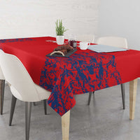 Red tablecloth with blue textured lion artwork, draped over dining table corner
