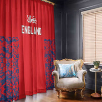 Red England window curtains with Three Lions crests and blue splatter panels, draped by a living-room chair.