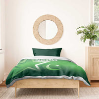 Green Pakistan duvet and single blanket layer, centered Pakistan logo with crescent and star