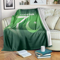 Green Pakistan cricket blanket with Pakistan text, crescent and star motif on a couch