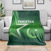 Green Pakistan cricket blanket spread on a gray sofa with Pakistan text and crescent star
