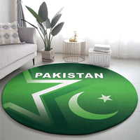 Green round Pakistan rug on living room floor with 'PAKISTAN' text, star and crescent