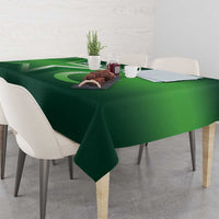 Green Pakistan-themed tablecloth on dining table with cups and small table decor.