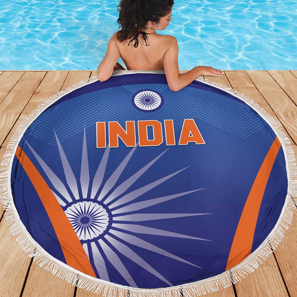 Blue round beach blanket with INDIA lettering, orange stripes, and white tassel fringe