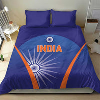 Blue duvet cover with India text and sunburst motif, orange diagonal accents, two pillows