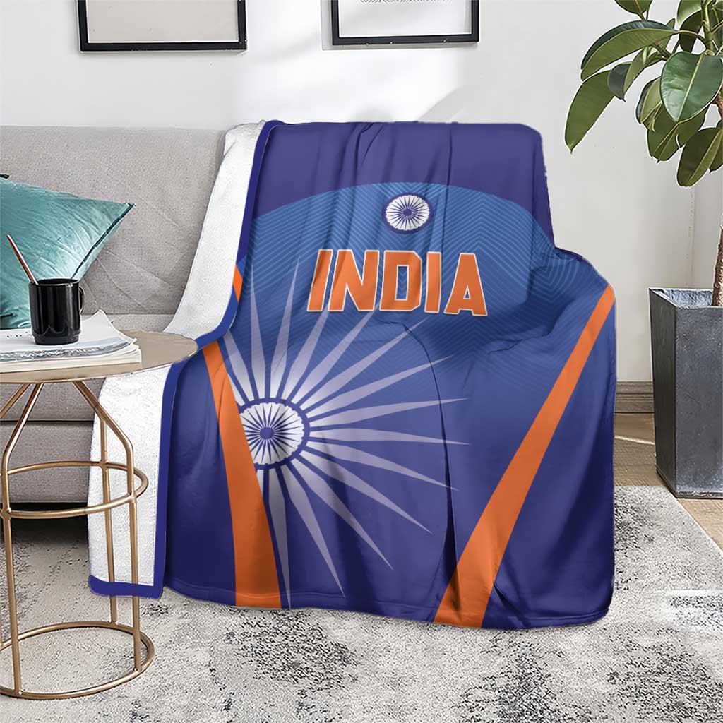 Blue cricket blanket with INDIA text and orange border, draped over a couch