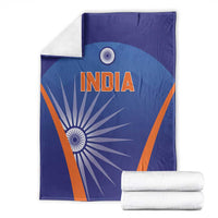 Blue India cricket blanket with INDIA logo and orange trim, with folded white towels