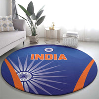 Blue round carpet featuring INDIA lettering and central white chakra on rays with orange edging