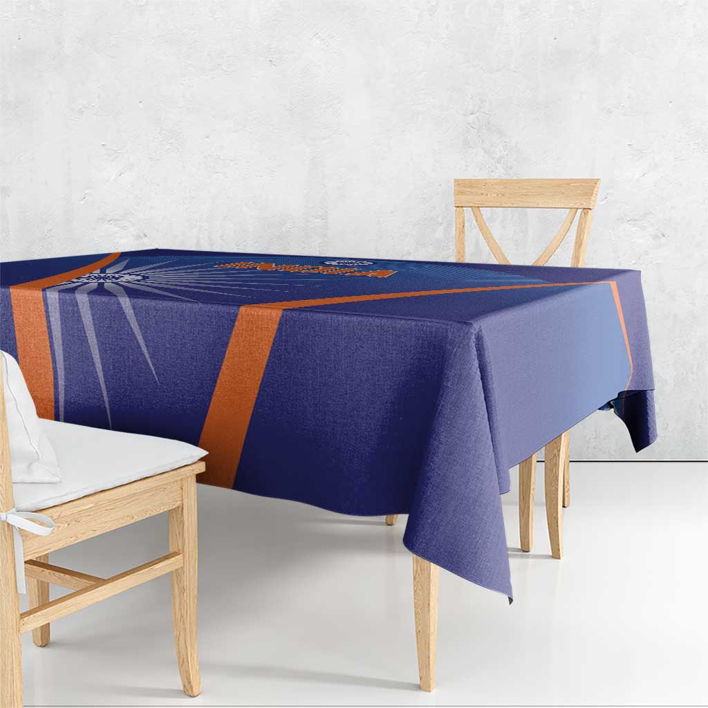 Blue India cricket tablecloth with orange stripe border, smooth fabric drape on table.