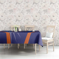 Blue India cricket tablecloth with orange stripe pattern on dining table setting.
