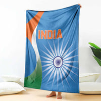 Blue India cricket blanket draped over couch, INDIA text and Ashoka chakra with green and orange