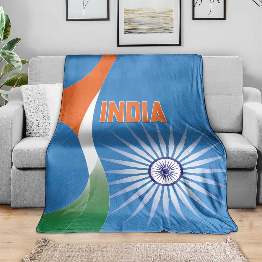 Blue India cricket blanket folded over sofa, INDIA lettering and chakra sunburst pattern