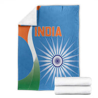 Blue India cricket blanket folded, tricolor curves, INDIA text, and chakra print beside rolled towels